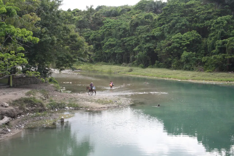 Der ruhige Fluss bei La Confluencia in Jarabacoa, umgeben von dichtem Wald.